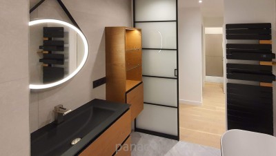 Salle de bain avec une porte coulissante et des meubles sur mesure